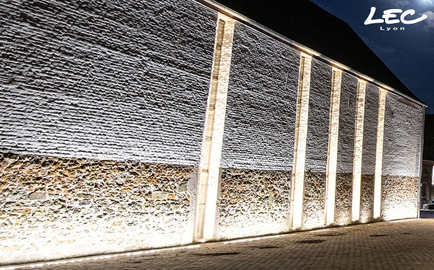 <p>5 projecteurs Allevard (5716) avec des optiques 10° sont encastrés au sol pour souligner les alcoves toute en hauteur qui jalonnent la façade. L'éclairage blanc chaud tranche avec le blanc neutre des 5620 qui éclairent la façade.</p>

